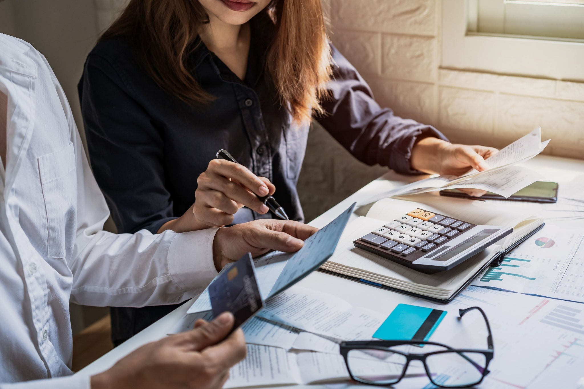  Deux comptables faisant des calculs à une table