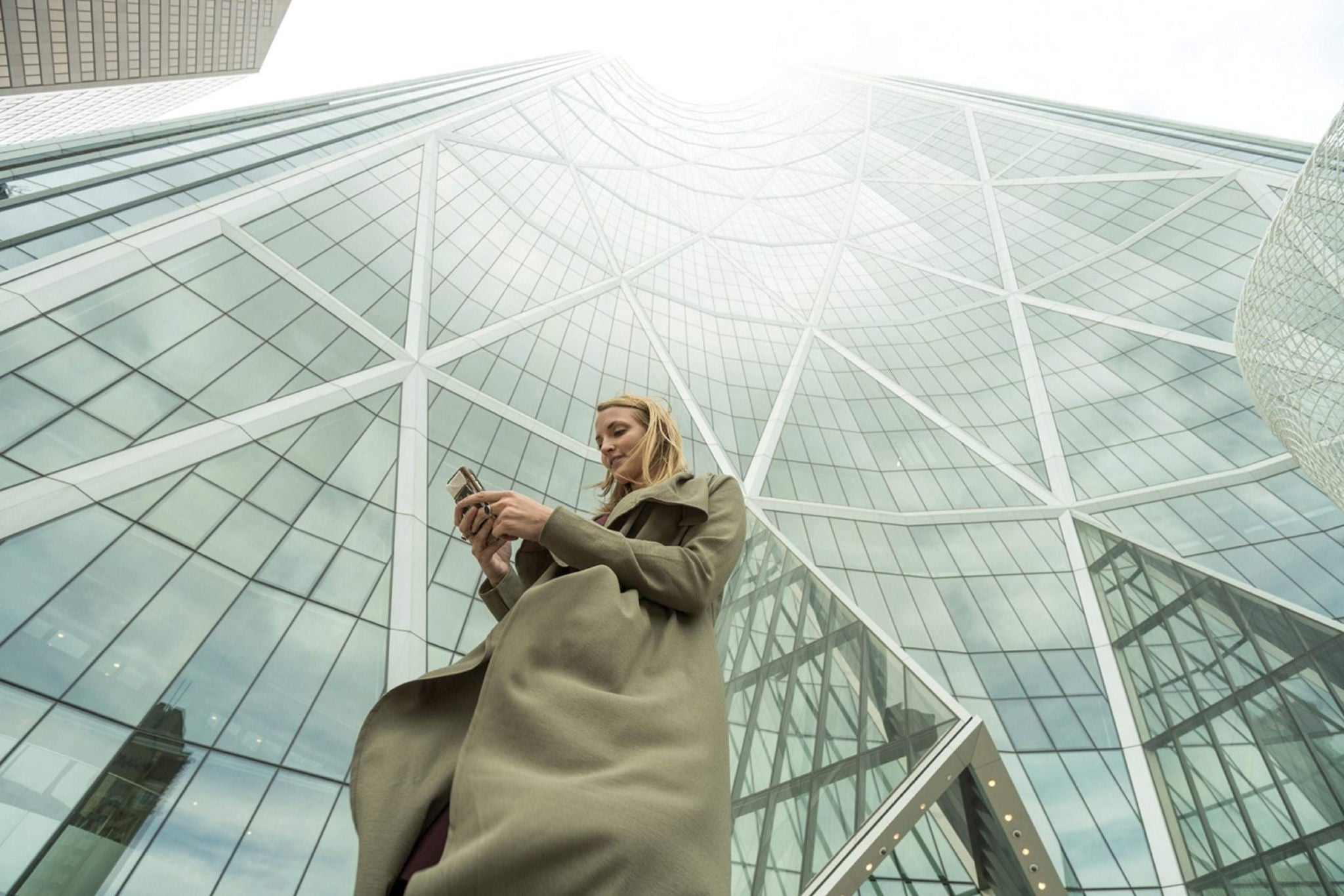 Femme utilisant son téléphone devant un building