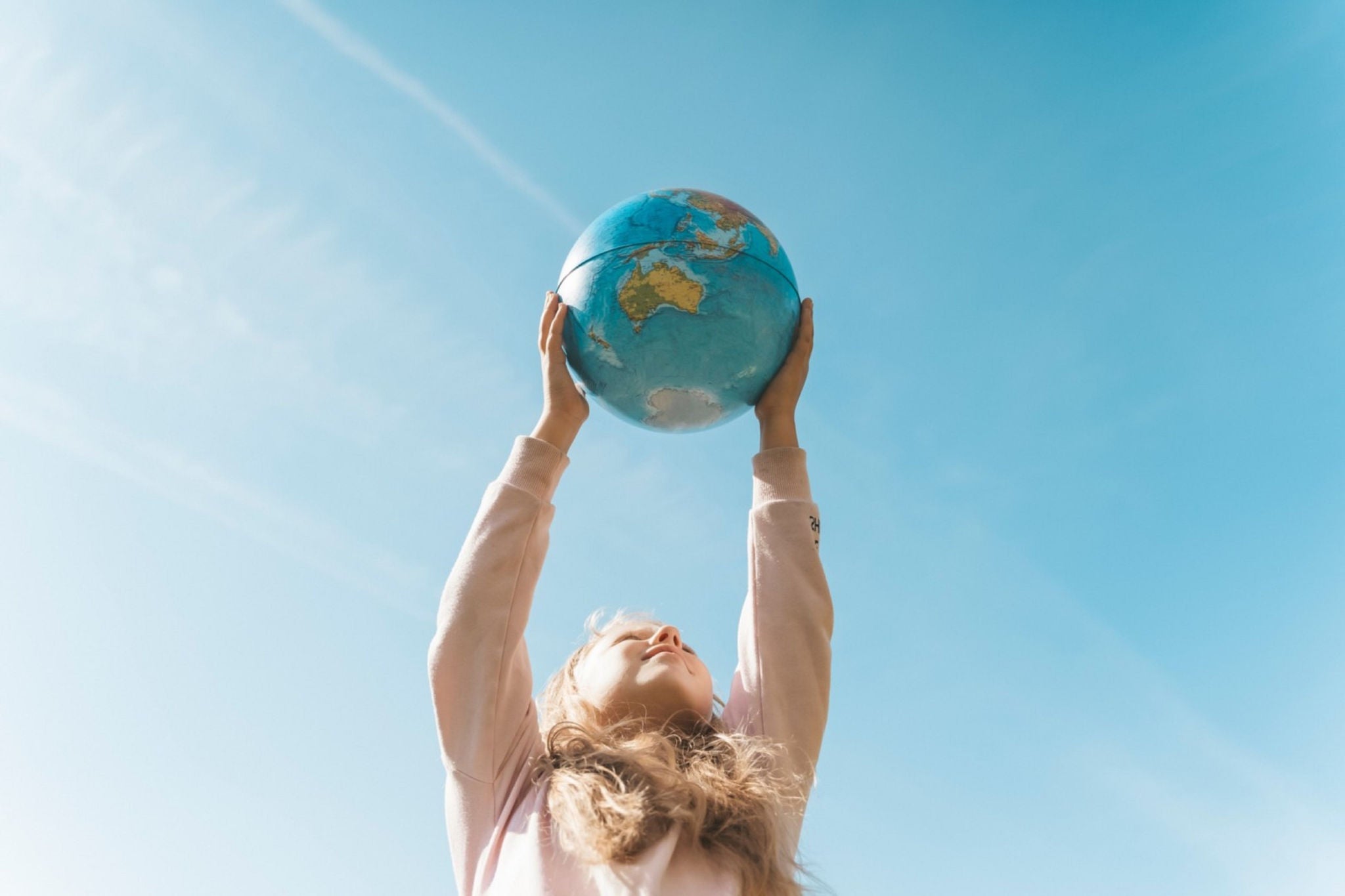  Petite fille tenant un globe terrestre en l’air