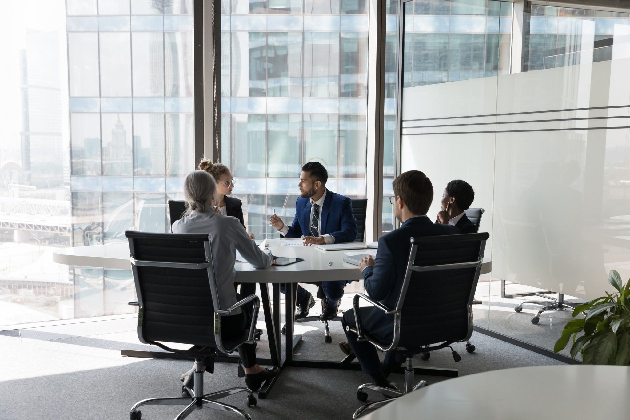 Réunion d'affaires dans un bureau vitré.