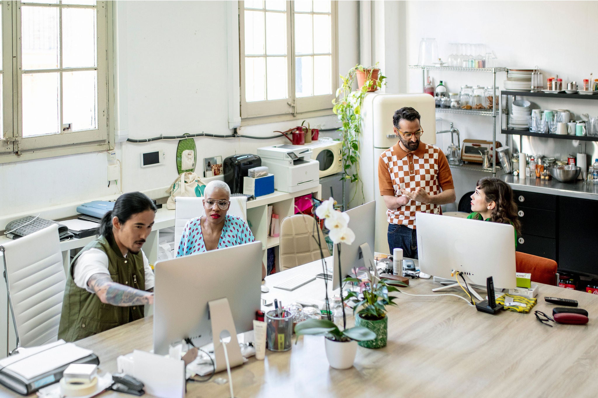 Male and female creative professionals working on computers. Business people are planning together at desk. They are working in office.