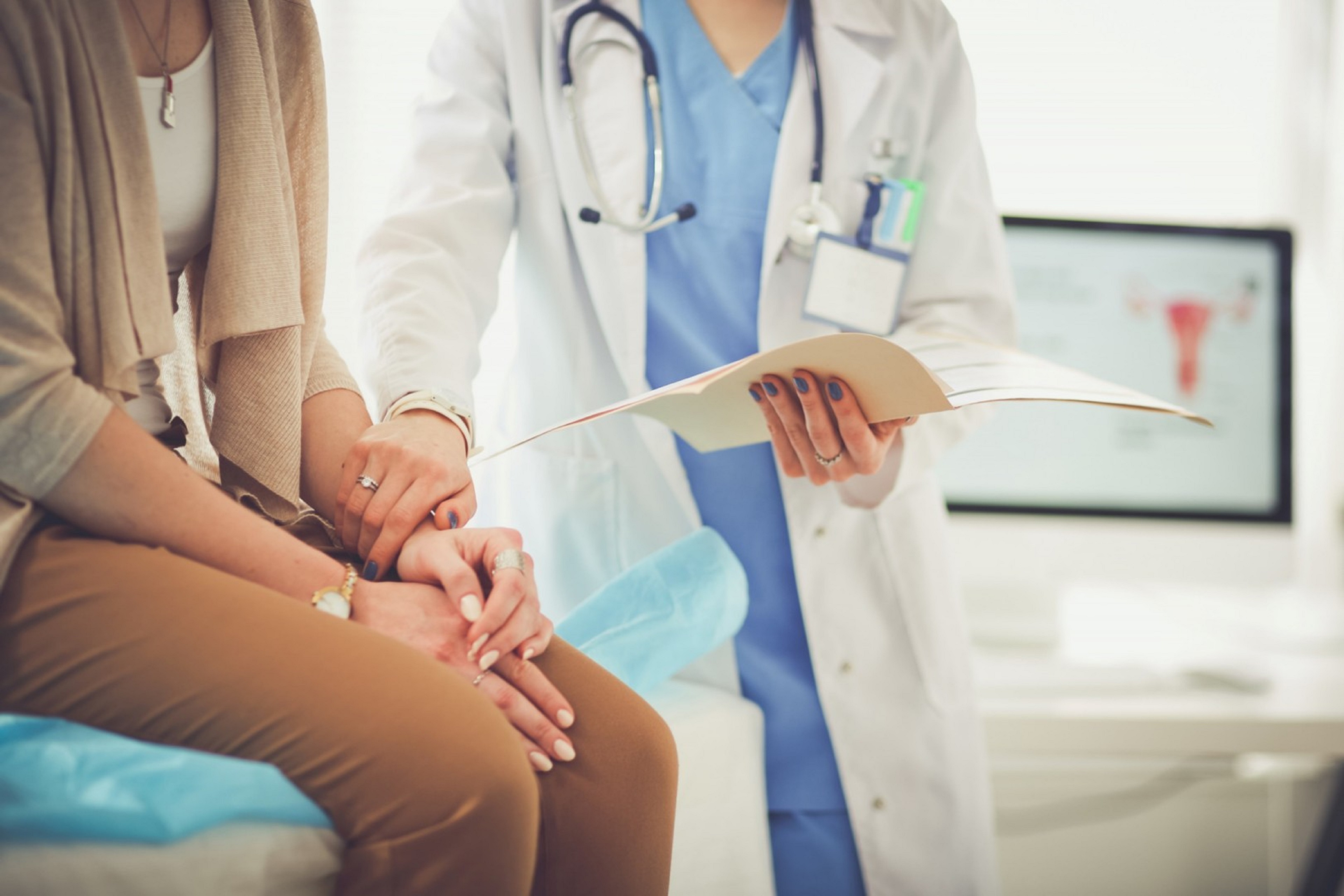 Docteur et patiente assise sur la table discutant