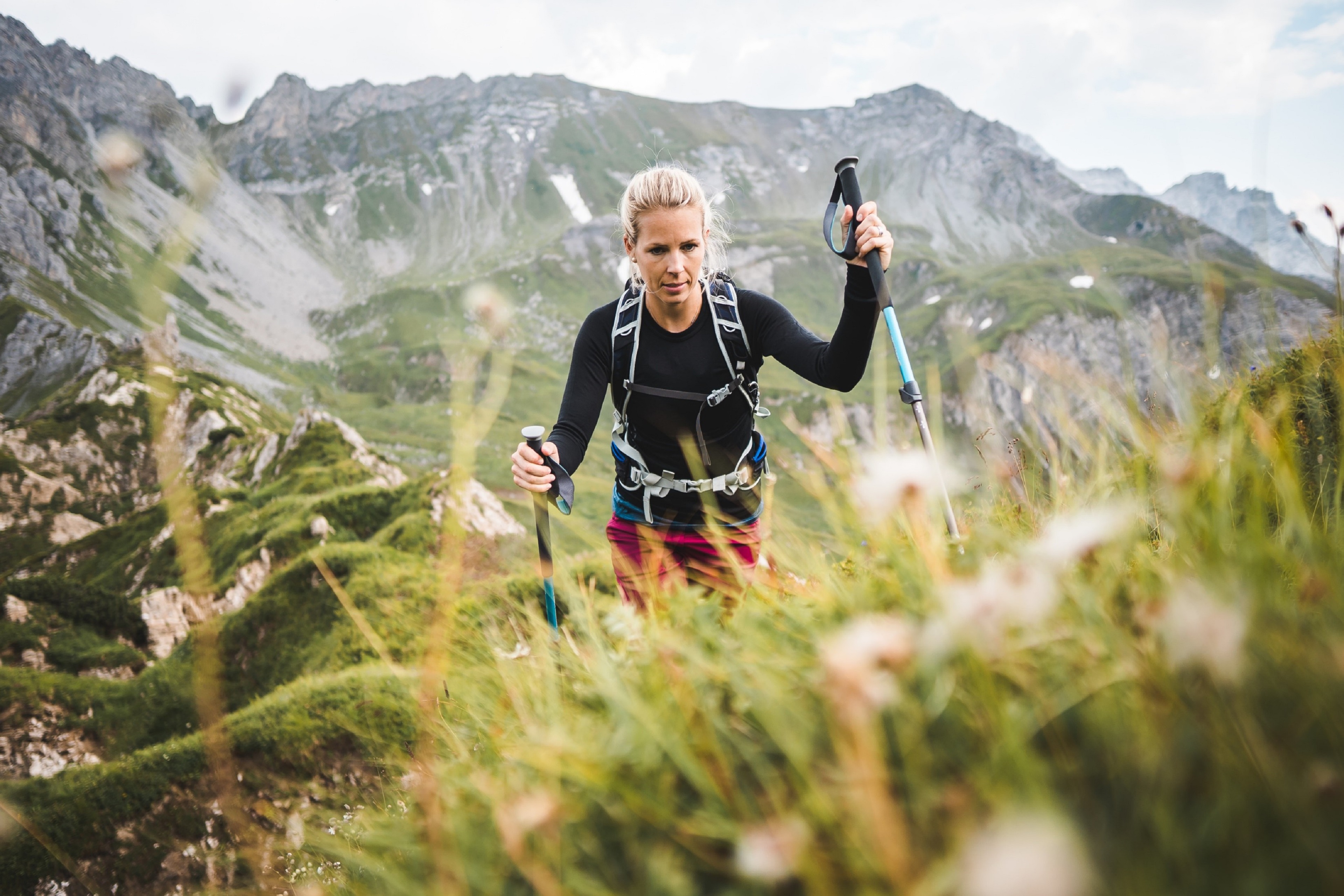 Une image représentant une femme seule en train de faire de la randonnée sur un sentier de montagne escarpé.